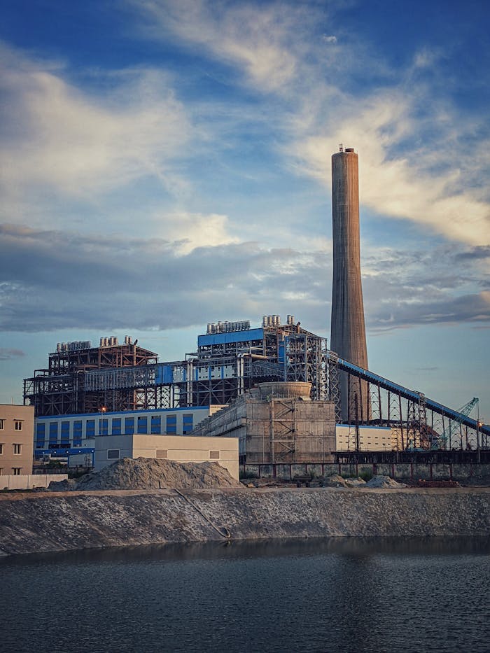 about-04 A large industrial power plant beside a river under a cloudy sky in Bangladesh.
