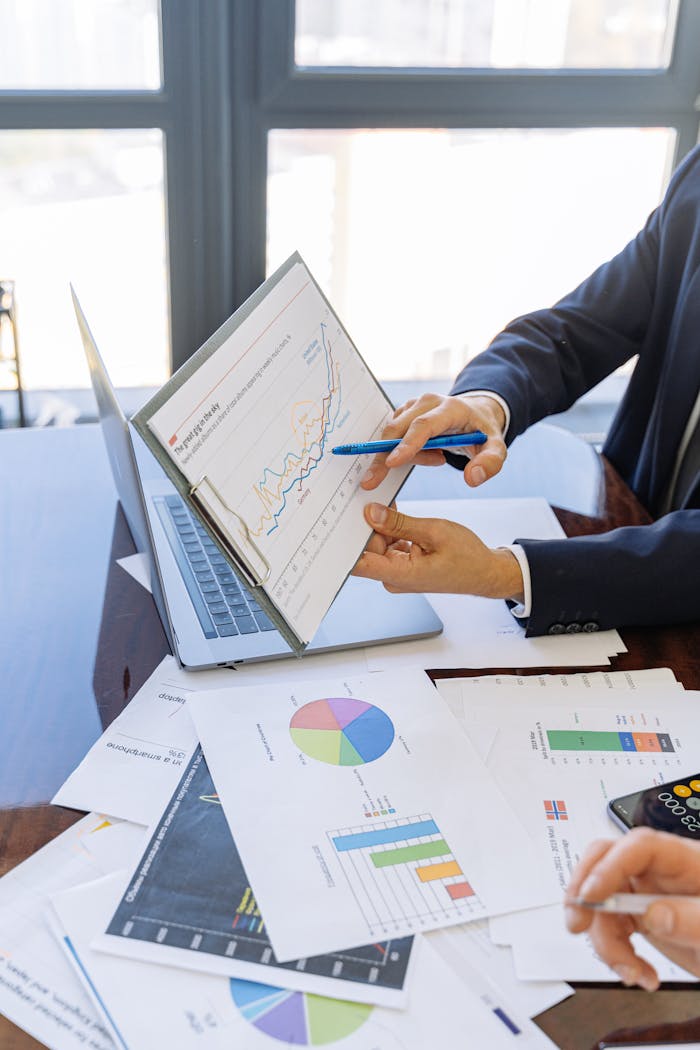 about-01 Business professionals discussing financial graphs and charts in an office setting.